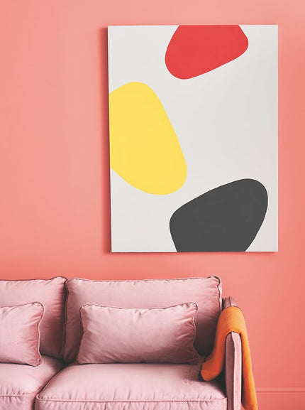Pinke Couch vor aprikosefarbener Wand, Kunstwerk im Hintergrund
